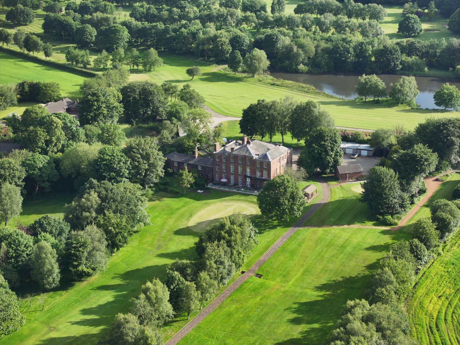 Cinematic view of clubhouse and lake at Hindley Hall Golf Club